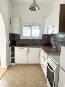 a kitchen with white appliances and a window at Ariadni's home - Einfamilienhaus mit Meerblick in Nea Stira