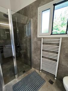 uma casa de banho com um chuveiro, um WC e uma janela. em Ariadni's home - Einfamilienhaus mit Meerblick em Nea Stira