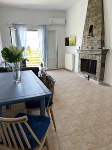 een woonkamer met een tafel en een open haard bij Ariadni's home - Einfamilienhaus mit Meerblick in Nea Stira