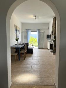 een eetkamer en een woonkamer met een tafel en stoelen bij Ariadni's home - Einfamilienhaus mit Meerblick in Nea Stira