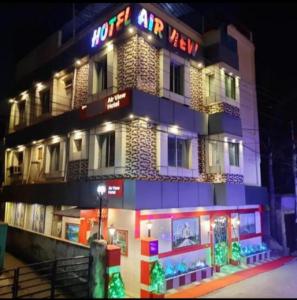 a building with a neon sign in front of it at Hotel Air View in kolkata