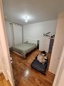 um quarto com uma cama e uma mala no chão em Read Well - Spare Double Bedroom in Cosy Appartment close to Convention Center in 15th District em Paris