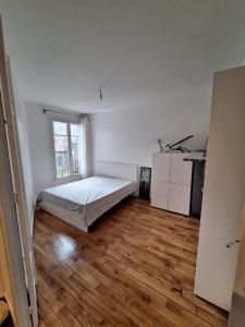 um quarto com uma cama e piso em madeira em Read Well - Spare Double Bedroom in Cosy Appartment close to Convention Center in 15th District em Paris