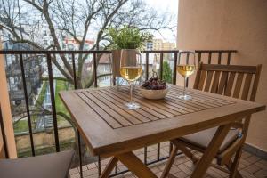 a table with two glasses of wine and a bowl of fruit at Apartmán u Výstaviště in Olomouc