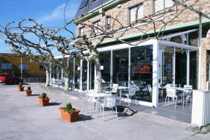 a restaurant with chairs and tables outside of a building at Pensión As Rodas in Sarria