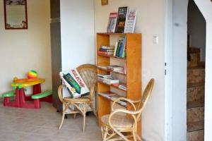 ein Zimmer mit 2 Stühlen und einem Bücherregal mit Büchern in der Unterkunft Chalupa Ohře in Libochovice