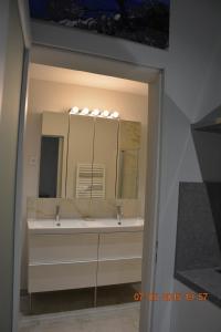 une salle de bain avec deux lavabos et un grand miroir dans l'établissement LA BAMBOUSERAIE, à Saint-Rémy-de-Provence