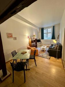 Appartement au cœur du vieux Rouen في رووين: غرفة معيشة مع طاولة وأريكة