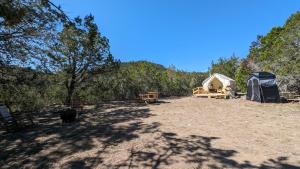 a campsite with a tent and a campsite with trees at A Peace of Heaven Cabins and RV in Vanderpool