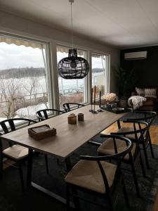 Koslig bolig med sjøutsikt في أسكير: طاولة طعام مع كراسي ونافذة كبيرة