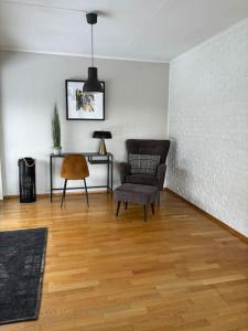 a living room with a chair and a table at Koslig bolig med sjøutsikt in Asker