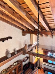 una habitación con una cuerda colgada de un techo de madera en Casa Rural Abuelo Regino, en Segovia