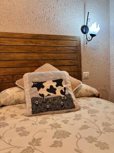 una cama con una almohada de vaca encima en Casa Rural Abuelo Regino, en Segovia