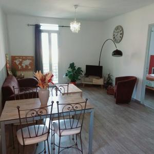- un salon avec une table et des chaises en bois dans l'établissement Logement Cosy 58m2 centre ville, à Perpignan
