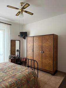 a bedroom with a bed and a ceiling fan at Lilly & Gisa casa vacanze in Pedara