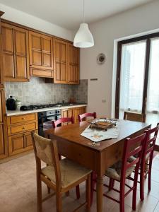 a kitchen with a wooden table and chairs at Lilly & Gisa casa vacanze in Pedara