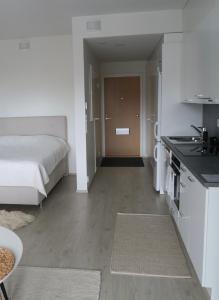 a bedroom with a bed and a kitchen with a sink at Ihana yksiö Kangasalan Harjunsalossa in Kangasala