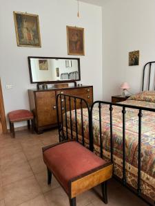 a bedroom with a bed and a chair and a dresser at Lilly & Gisa casa vacanze in Pedara