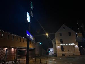 a clock on a pole in front of a building at night at Durmaz Hotel in Hannover