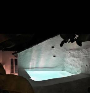 a snow covered building with a light on it at night at Casa Rural Recovecos in Algodonales