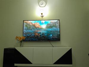 una TV a schermo piatto seduta sopra un armadio bianco di Homestyle Haven with Secure Parking & Free WiFi a Embu