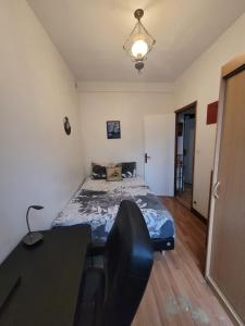 a bedroom with a bed and a table and a desk at Evasion du Stade in Saint-Denis