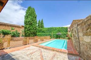 una piscina en un patio con una pared de piedra en Casa Bermeja, en Valdeverdeja