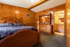 1 dormitorio con cama grande de madera y vestidor en Sleeps 6, 3br, Fully Furnished, On-site Fun, en Neillsville