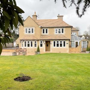 a large house with a large lawn in front of it at Southlands B&B in Bourton on the Water