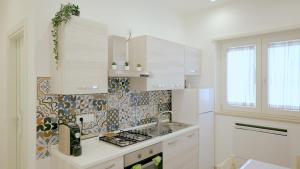 een witte keuken met een wastafel en een fornuis bij Villa Zefiro Suites e Events in Battipaglia