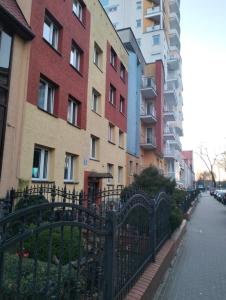 a fence in front of a row of buildings at komfortowy pokój nad morzem in Kołobrzeg