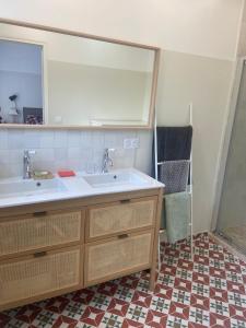 La salle de bains est pourvue d'un lavabo et d'un grand miroir. dans l'établissement Cosy house in Versailles - Paris 2024, à Versailles