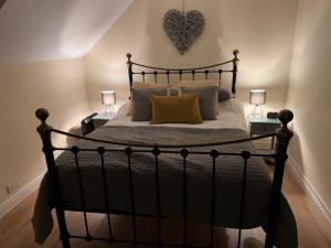 1 dormitorio con 1 cama con un corazón en la pared en Kellsboro Corner, en Fairford