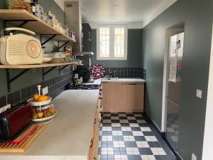 een keuken met een zwart-witte tegelvloer bij Cosy house in Versailles - Paris 2024 in Versailles