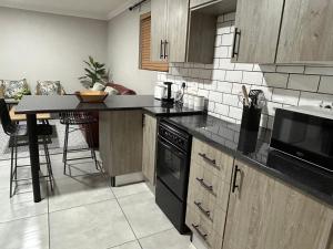 a kitchen with wooden cabinets and a counter top at Hansen@15 Self Catering Studio in Piet Retief