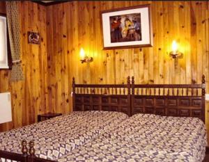 a bedroom with a wooden wall with a bed at Le P'tit Caribou, près des pistes in Gérardmer