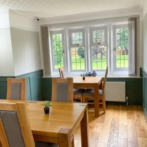 a dining room with a table and chairs and windows at Southlands B&B in Bourton on the Water