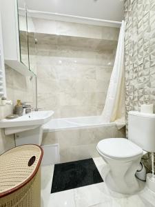 a bathroom with a toilet and a sink and a tub at Gio Apartment in Chişinău