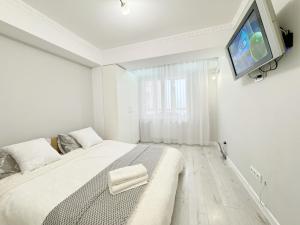 a bedroom with a bed with a tv on the wall at Gio Apartment in Chişinău