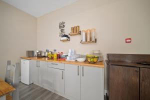 a kitchen with white cabinets and a wooden counter top at Queensferry Guest house in Rosyth