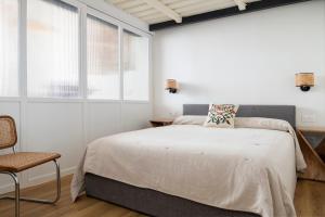 een slaapkamer met een groot bed en een stoel bij Tranquilo acogedor y céntrico 2beds & 2bath in Sevilla