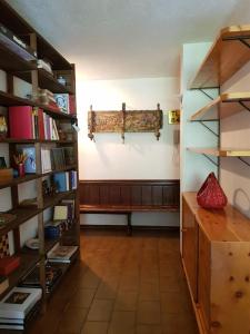 a room with a bench and a shelf with books at Appartamento Valdobbia in Gressoney-Saint-Jean