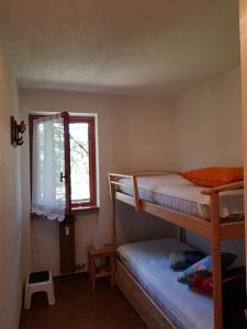 a bedroom with two bunk beds and a window at Appartamento Valdobbia in Gressoney-Saint-Jean