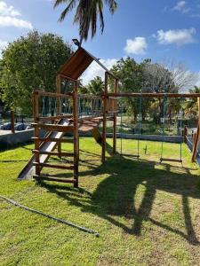 a wooden playground with a slide in a park at Casa de praia Itamaracá - Pontal da Ilha in Itamaracá