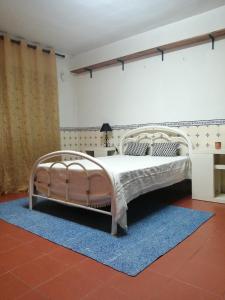 - une chambre avec un lit blanc et un tapis bleu dans l'établissement Good Sleep, à Santarém