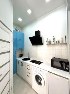 リヴィウにあるRomantic Apartment in the Сity Сenterのキッチン(洗濯機、青いキャビネット付)