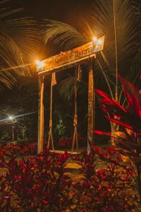 een swingiety met een straatnaambord er 's nachts op bij Magic Green Dentro del Parque Tayrona in El Zaino