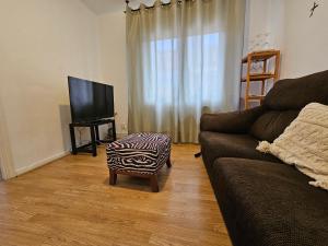 sala de estar con sofá y TV en 635A Acogedor apartamento en Oviedo, en Oviedo