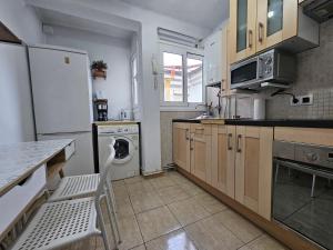 cocina con nevera, lavadora y secadora en 635A Acogedor apartamento en Oviedo, en Oviedo