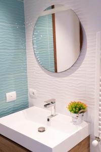 un baño con lavabo y espejo en Monteleone Apartment, en Palermo 38 fotos más